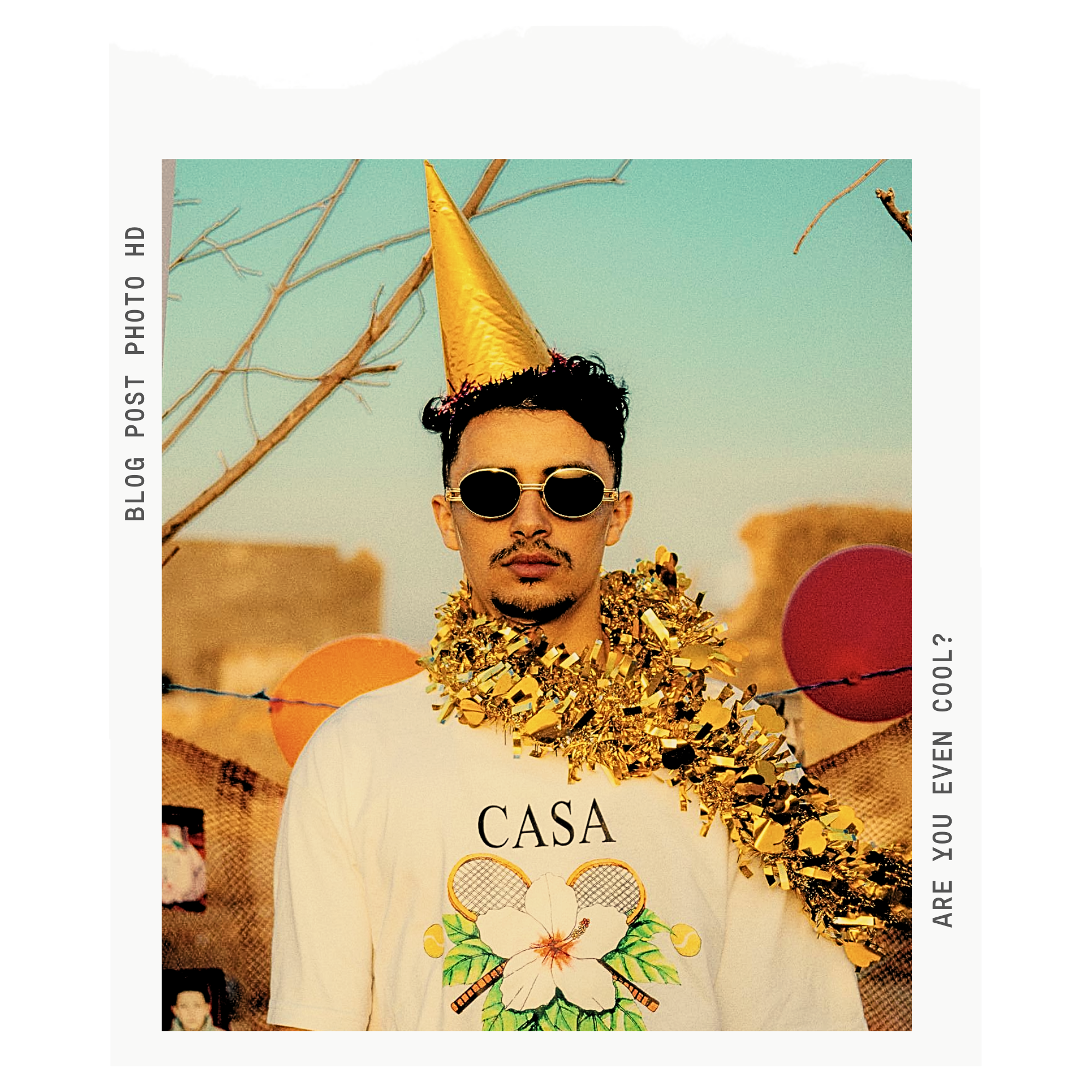 man looking uncelebratory while wearing a confetti boa and a party hat and sunglasses like he's too cool for the party